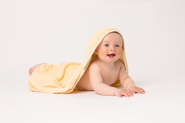 oddler boy with yellow towel on head on white background, Portrait of cute Caucasian newborn baby. The child is wrapped in a yellow soft towel after bathing. Clean and happy little baby in after wash