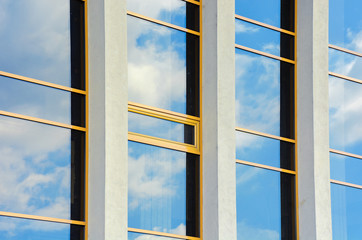 beautiful urban architecture background. window reflection of a clouds on a blue sky. perspective side view with three columns