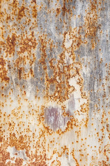 Background textures of old rusty damaged metal. Remains of multi-colored paint on an iron sheet.
