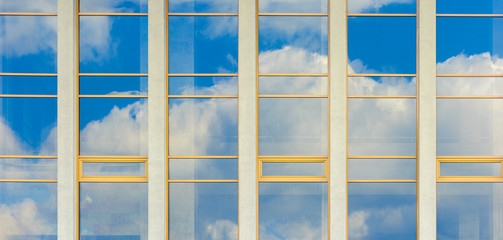Fototapeta premium beautiful urban architecture panoramic background. window reflection of a clouds on a blue sky. 
