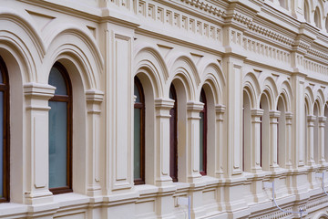 Perspective view on a facade of ancient stone building with decorative ornaments and windows