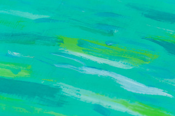 Turquoise wooden board with green paint stains as background, texture (abstract)
