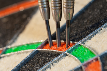 Close up view on three darts in triple sector of sisal dartboard