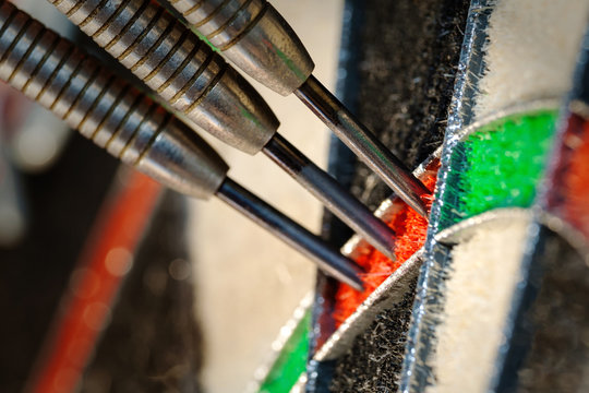 Close up view on a three darts in triple twenty sector of sisal dartboard