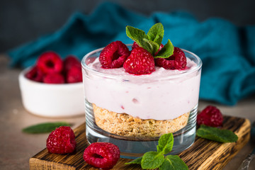 No baked cheesecake with raspberry in glass jar.