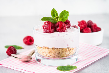 No baked cheesecake with raspberry in glass jar.