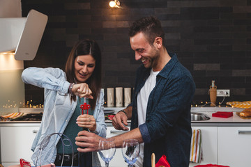 young couple of lovers celebrating at home drinking wine