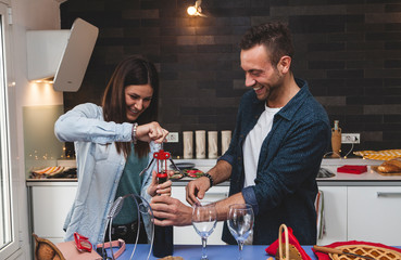 young couple of lovers celebrating at home drinking wine