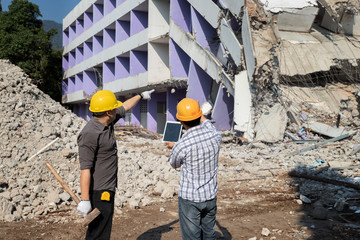 Demolition control supervisor and foreman discussing on demolish building.