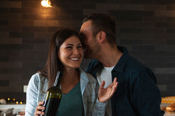 young couple of lovers celebrating at home drinking wine