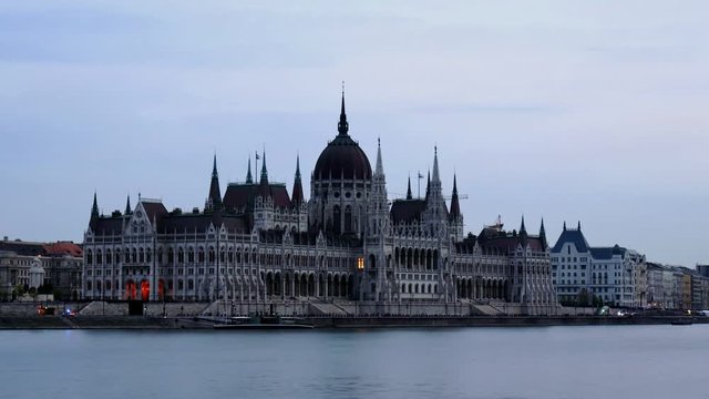 Budapest day to night time lapse at Hungarian Parliament and boats cruising on Danube River seen from margit hid.