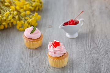 Tasty cupcake on wooden background. Birthday cupcakes on gray wooden background. Cupcakes with Mini heart-shaped jellies. Space for Text. Cupcake Thailand.