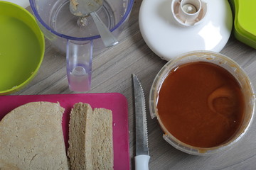 Sliced halva from honey, peanuts and sunflower seeds. Next honey in the container. Ingredients and tools for making halva.