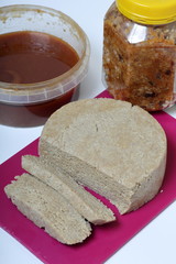 Sliced halva from honey, peanuts and sunflower seeds. Near honey in different containers. Ingredients and tools for making halva.