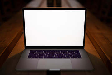 Blank empty screen of laptop in cafe on table
