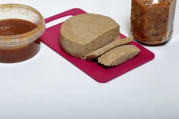 Sliced halva from honey, peanuts and sunflower seeds. Near honey in different containers. Ingredients and tools for making halva.