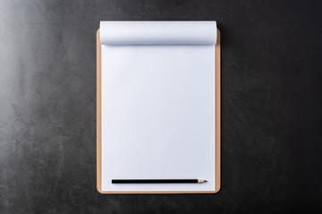 white paper with clipboard on black stone background