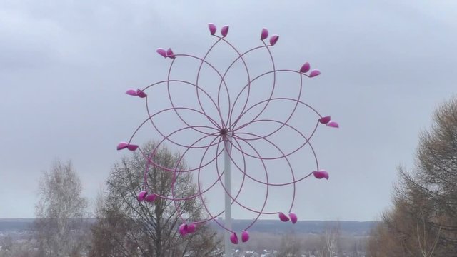 Unusual windmill twists its blades against the gray sky