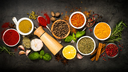 Set of various spices on black background.