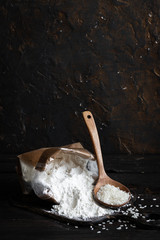 White rice flour in a crafting bag on a dark wooden background