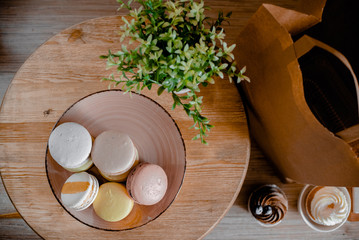 Kitchen plate with colorful macaroon. Wooden table