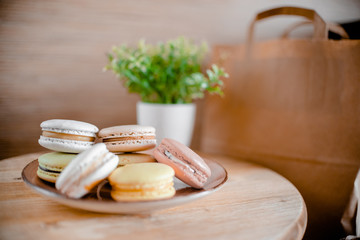 Kitchen plate with colorful macaroon. Wooden table