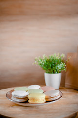 Kitchen plate with colorful macaroon. Wooden table