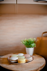 Kitchen plate with colorful macaroon. Wooden table