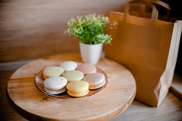Kitchen plate with colorful macaroon. Wooden table