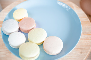 Kitchen plate with colorful macaroon. Wooden table