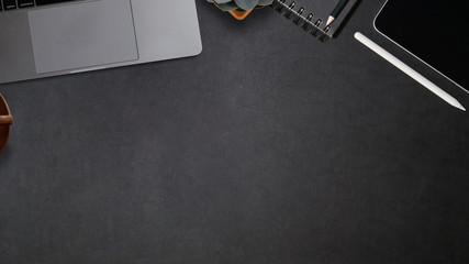 Creative dark leather desk with laptop, and copy space