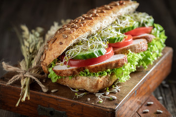 Tasty sandwich with grilled chicken, tomato and cucumber