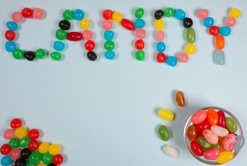 Candy writen in jelly beans at a blue background with copy space for your own text