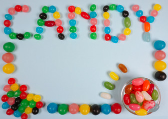Candy composition with coloful jelly beans nice for an birthday party invitation on a blue background with copy space for your own text