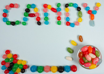 Candy composition with coloful jelly beans nice for an birthday party invitation on a blue background with copy space for your own text