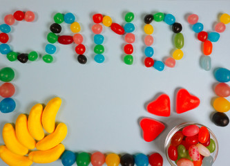 Sweets and candy colorful jelly beans in glass at a blue background