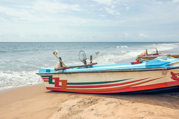 colorful wooden fishing boat on beach in sri lanka 