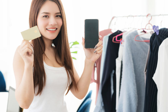 smart beautiful asian woman enjoy  choose shopping cloth or shop owner business entrepreneur hand hold smartphone credit card technology ideas concept