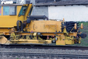 yellow repair locomotive stands on the rails of the railway