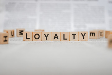 Fototapeta na wymiar Loyalty Word Written In Wooden Cube - Newspaper 