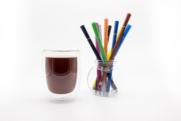 a glass of coffee and fiber pens, isolated on a white background