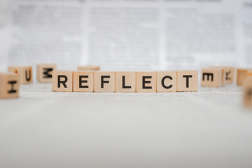 Reflect Word Written In Wooden Cube - Newspaper 