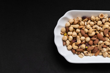 nuts, cashew nuts, dry almonds all close up on a plate, dry foods on black ground, nuts,