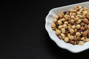 nuts, cashew nuts, dry almonds all close up on a plate, dry foods on black ground, nuts,