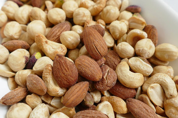 nuts, cashew nuts, dry almonds all close up on a plate, dry foods on black ground, nuts, nuts, peeled hazelnuts, cashews and almonds, stand together,