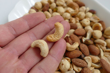 a man has cashew nuts in his hand,