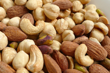 nuts, cashew nuts, dry almonds all close up on a plate, dry foods on black ground, nuts, nuts, peeled hazelnuts, cashews and almonds, stand together,