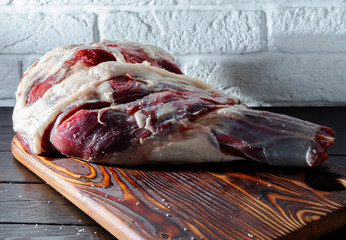 Raw lamb leg on a wooden board © Denis