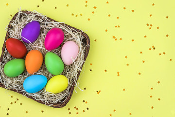 Fototapeta na wymiar Colored Easter eggs in the basket. Flatlay.