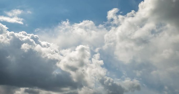 Time lapse clip of gray fluffy curly rolling clouds before storm in windy weather with sun rays